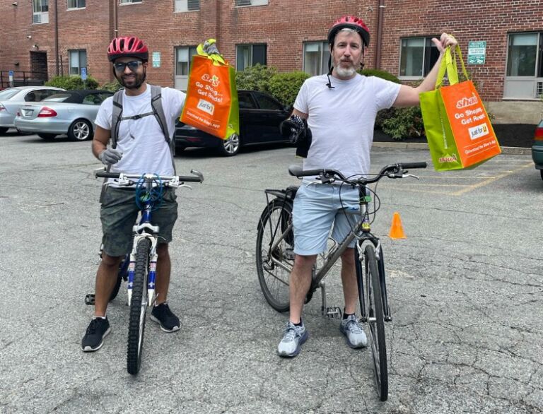 Two people on bikes with trash bags