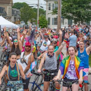 Dozens of cyclists in festive attire waving