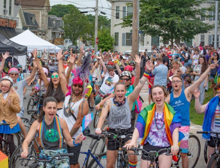 Dozens of cyclists in festive attire waving