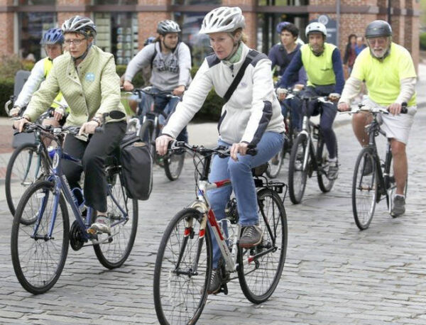 Group of helmeted cyclists on a cobblestone street