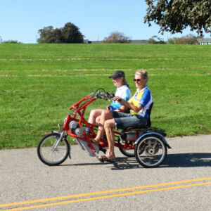 two riders on a red adaptive bicycle