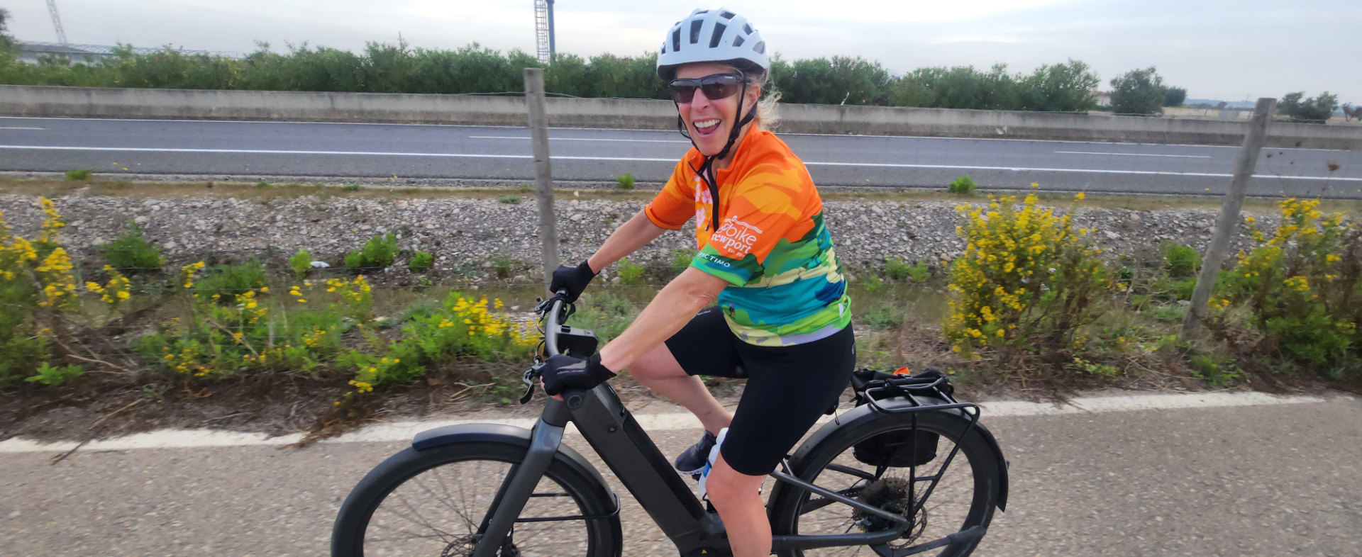 Smiling woman in cycling gear riding an e-bike