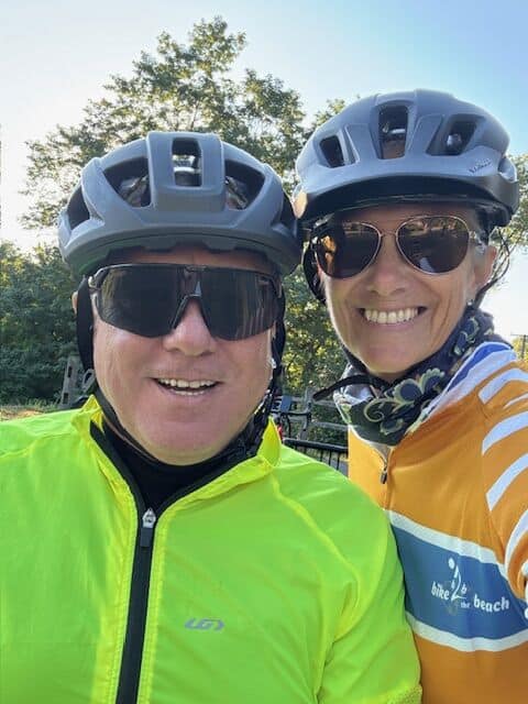 People wearing cycling helmets and sunglasses posing outdoors for a bike ride.