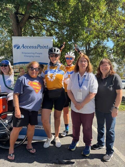 Group photo of diverse cyclists smiling at Bike Newport outdoor event, promoting cycling safety and community engagement in Rhode Island.