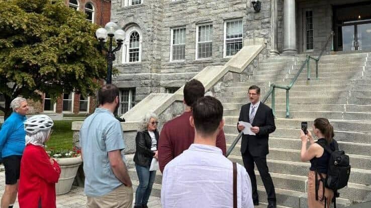 People gathered listening to a speaker outside a historic building in Newport Rhode Island.