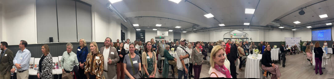 Vibrant indoor community event with diverse attendees at Bike Newport conference or gathering.