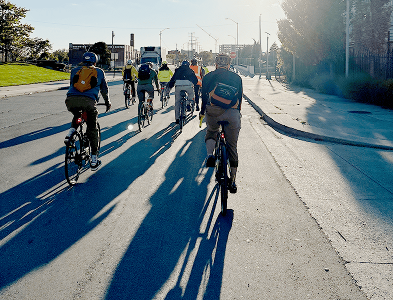 Group of cyclists riding together on a city street in Newport, promoting bike safety and community biking events.