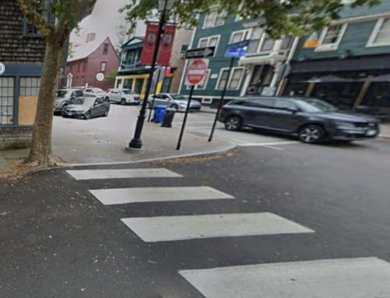 A snowy city street with visible curb extensions and pedestrian crosswalks, showcasing how snow reveals street design features that can improve pedestrian safety and bike infrastructure in urban areas.
