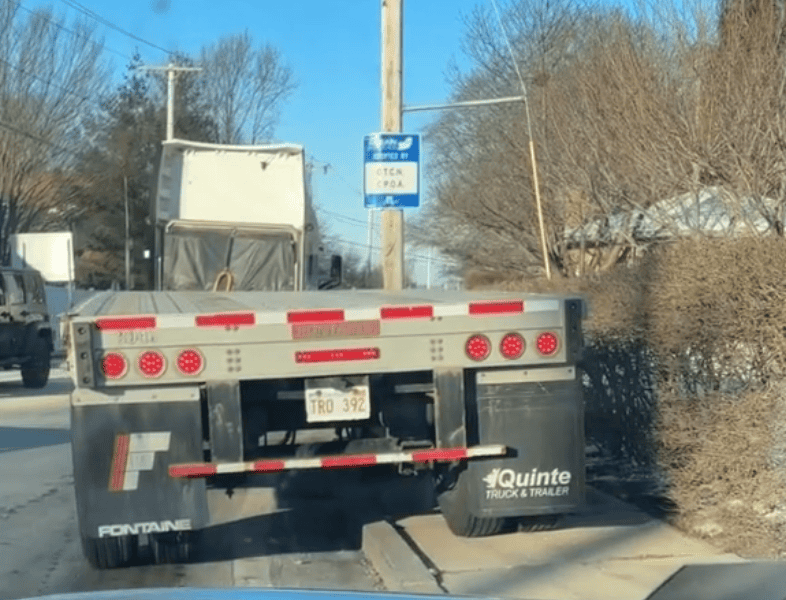 Delivery truck parked on a city street near a bike lane sign in Newport, Rhode Island, showcasing urban transportation and bike-friendly infrastructure.