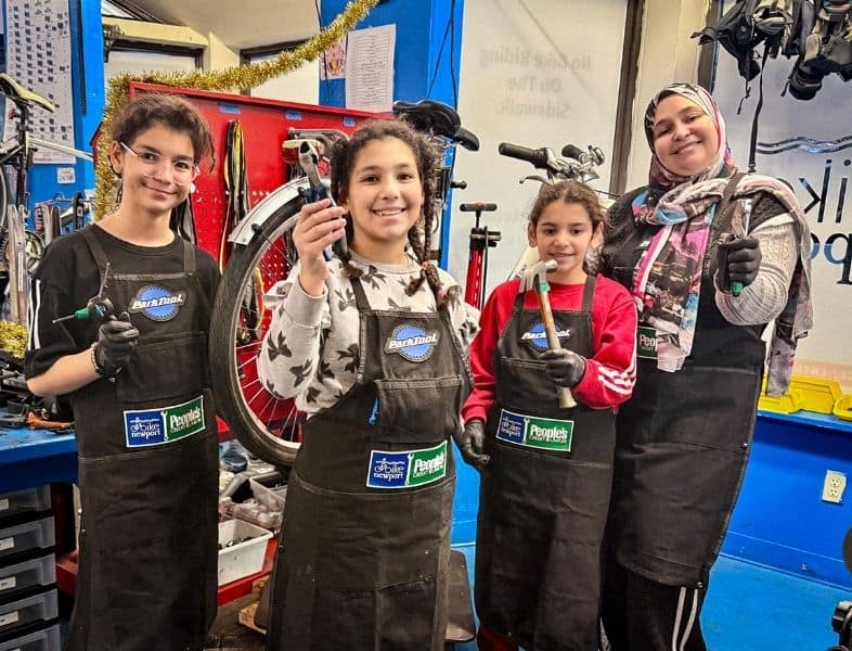 Family repairs bikes together in the bike garage