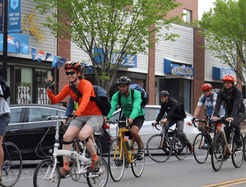 Cyclists riding together in a diverse and inclusive biking community in Rhode Island, promoting safe and accessible cycling for all.