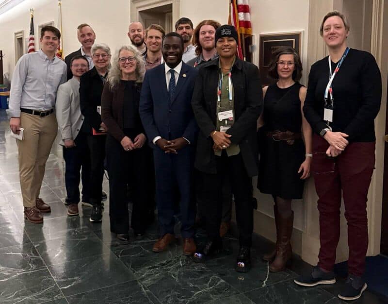 Diverse group of cycling advocates at the National Bike Summit 2026, emphasizing diversity and inclusion in cycling advocacy, standing together in a formal setting.