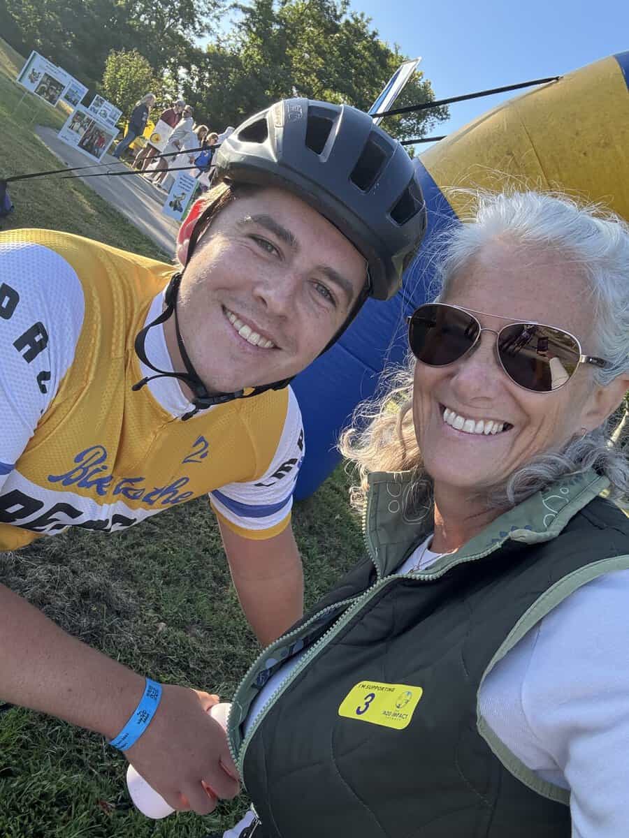 Chris Burich in a yellow Bike to the Beach jersey smiling next to a woman wearing an ADD Impact Network supporter badge